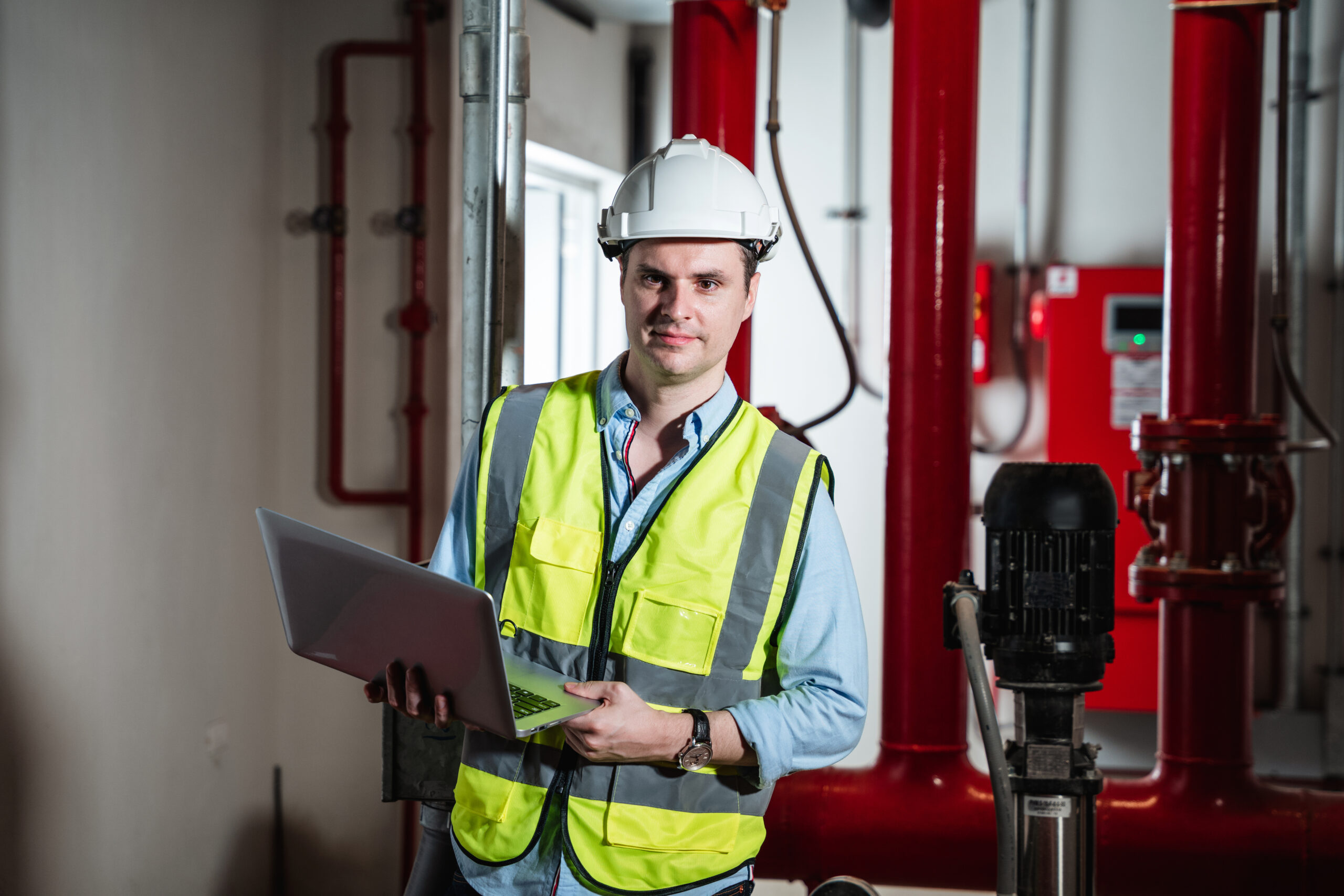 Engineers inspecting the inside plumbing and water valves of an industrial facility.